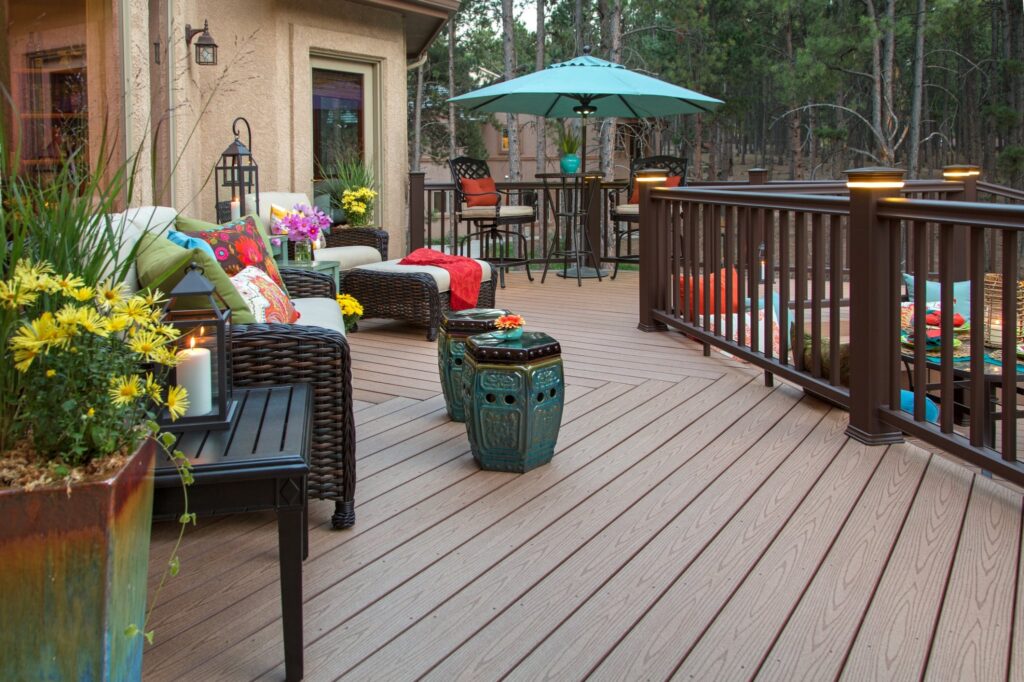 Large deck area outside of residential home with various patio furniture and décor placed throughout