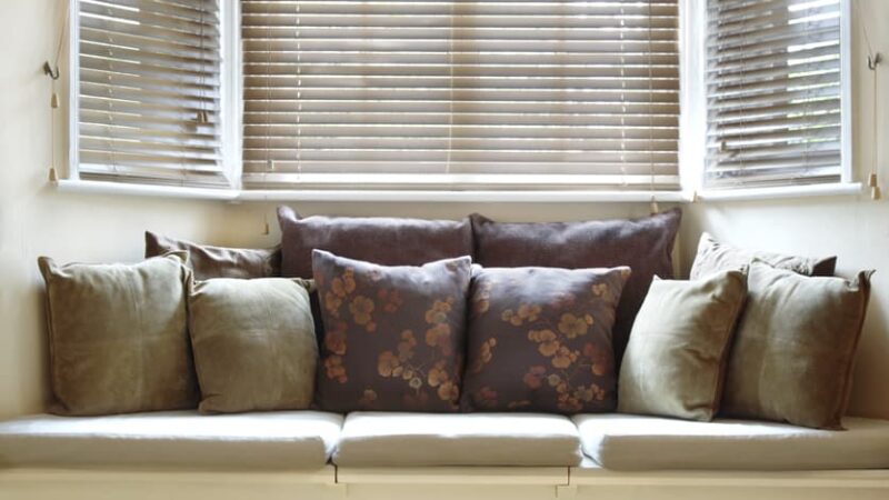Bay window seat with pillows and blinds