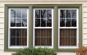 Double-hung windows with green trim on front of house 