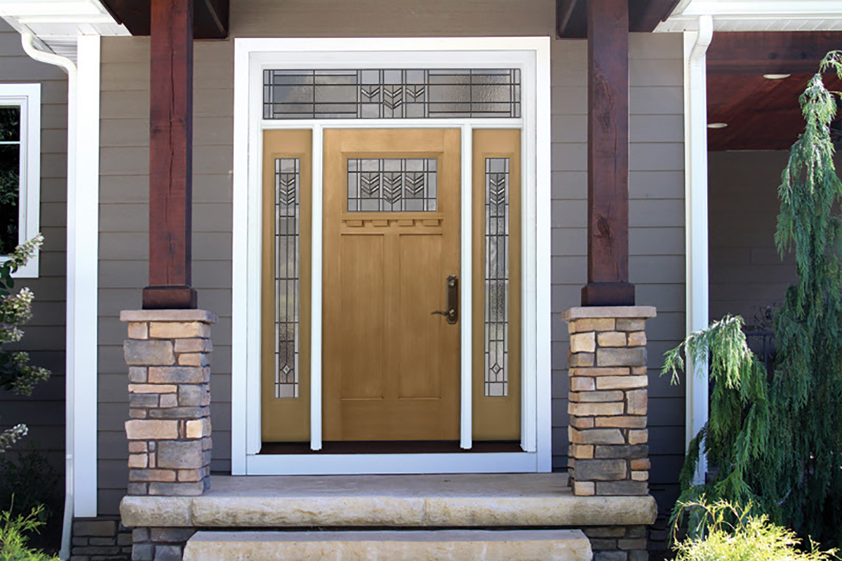 Entryway with wood and glass front door and stone pillars on each side