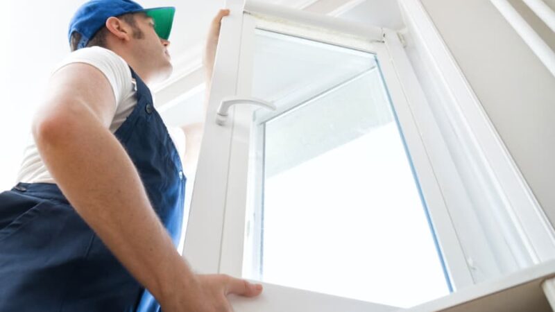 Handyman installing casement window in home
