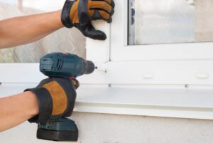 Installation specialists using tool to correctly install vinyl window 