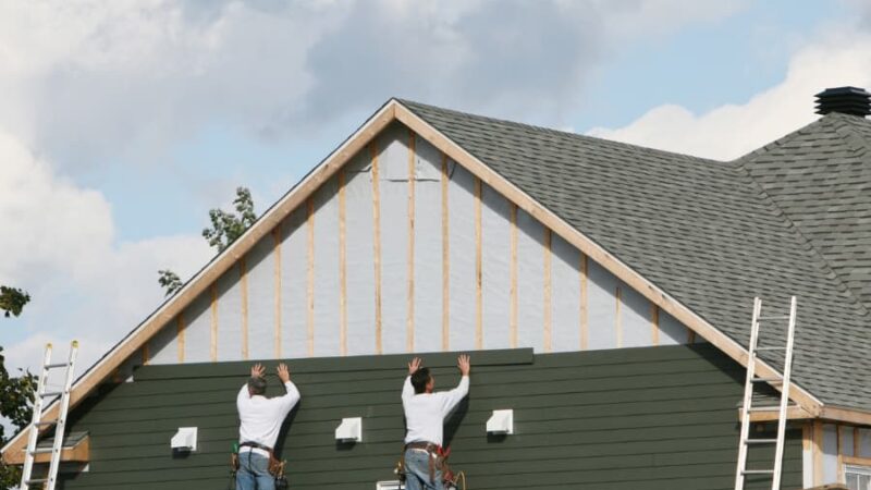 Siding installation technicians installing composite siding to client’s home