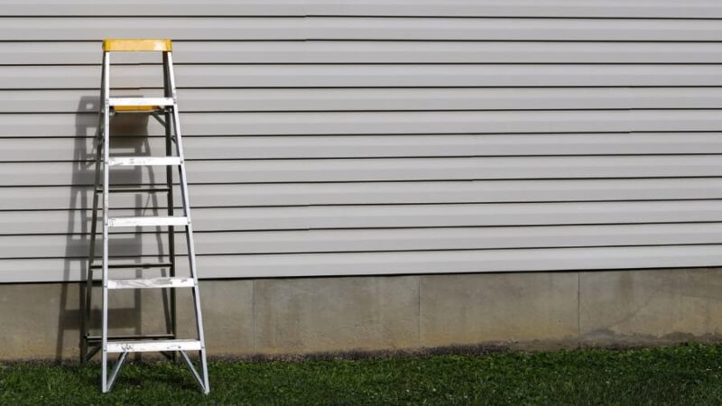 Ladder leaning on house with siding