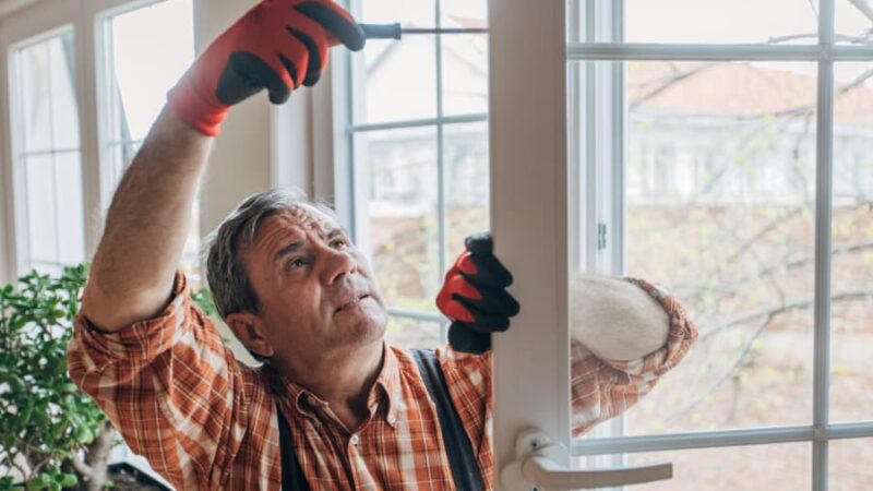 Worker installing replacement windows in home