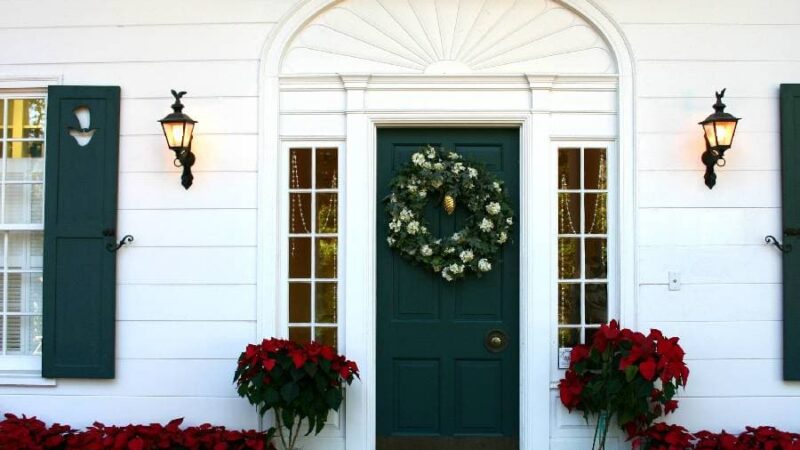 Colonial style front door decorated with flowers and wreath