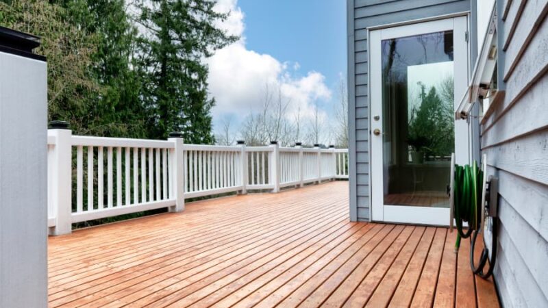 Stained large cedar wood deck with trees in background