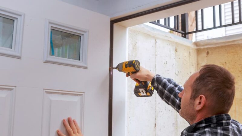 Construction worker installing new entry door